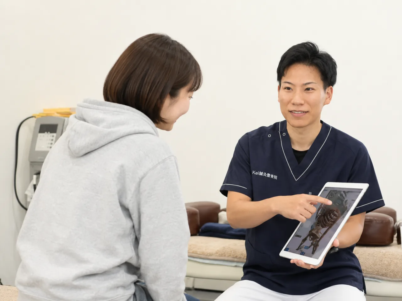 頚椎症性神経根症の相談で首や腕のしびれについて説明する施術者